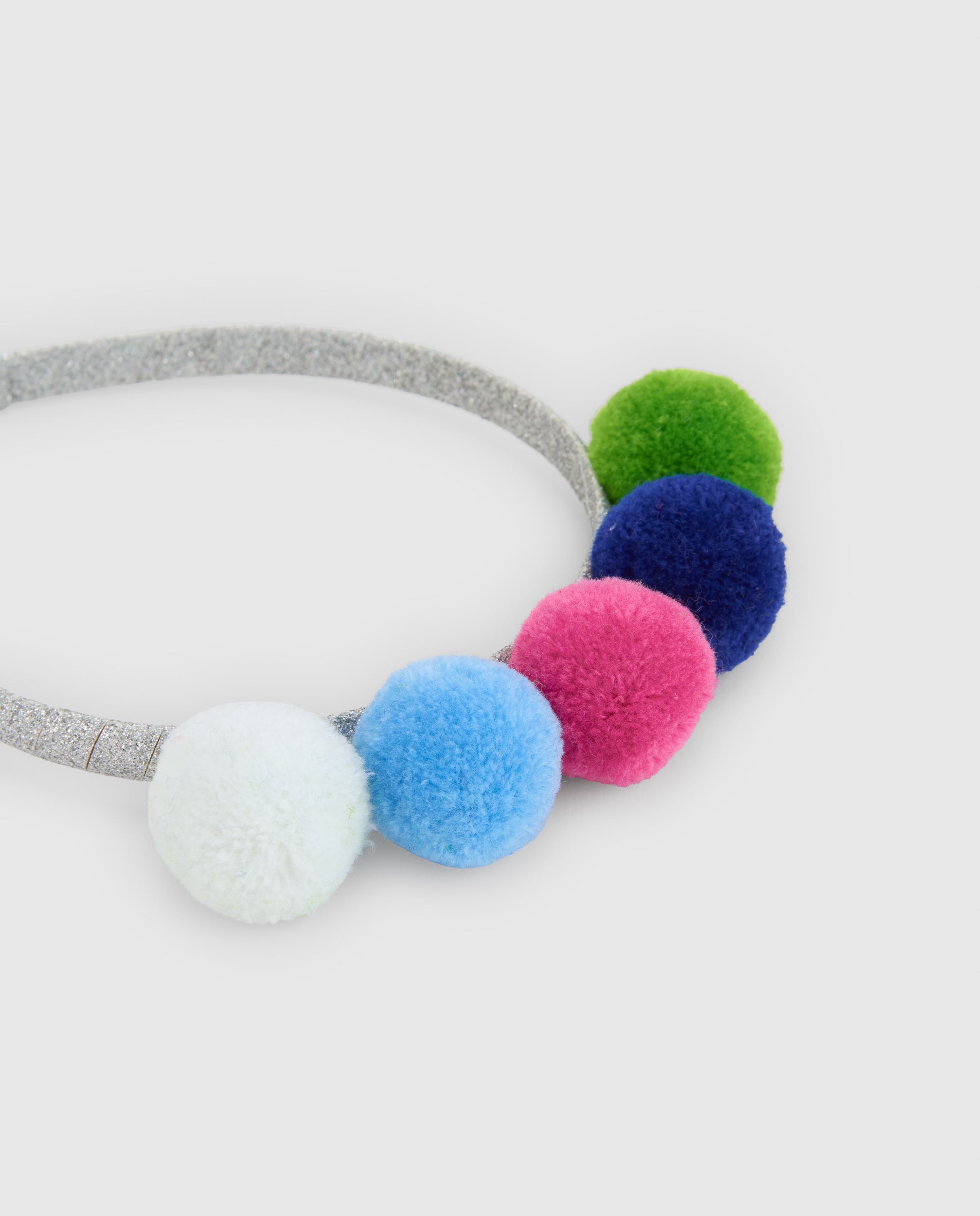 Diadema de niña con pompones de colores y detalles de brillo