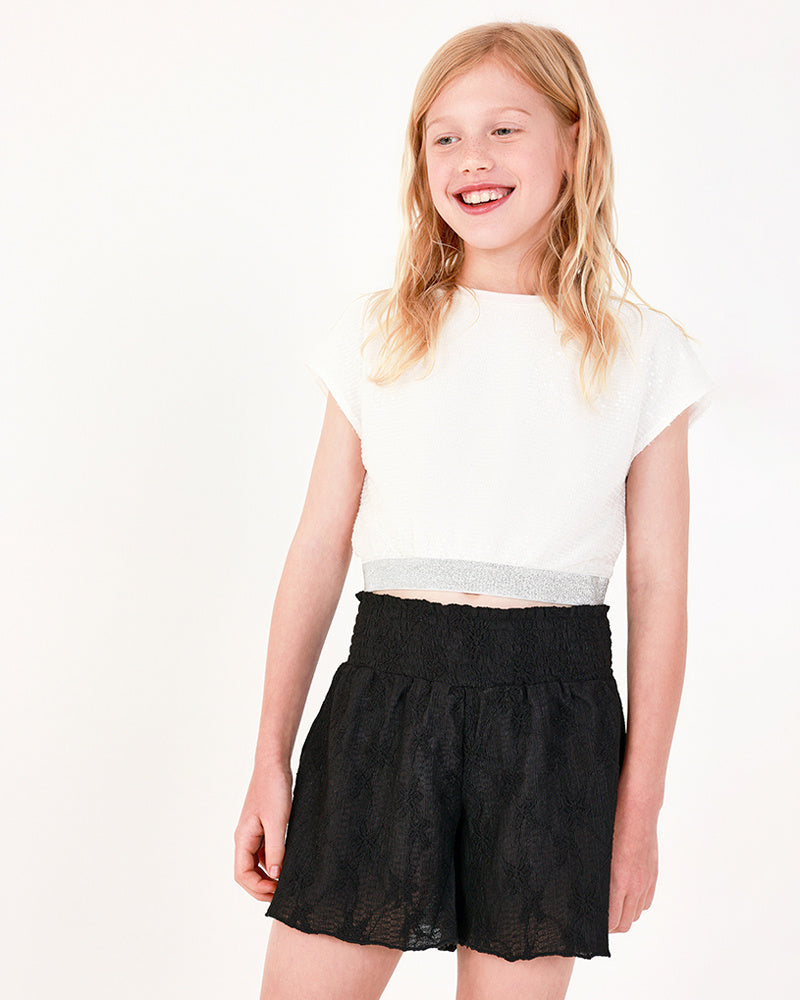 Camiseta para niña en blanco con lentejuelas y bajo elástico