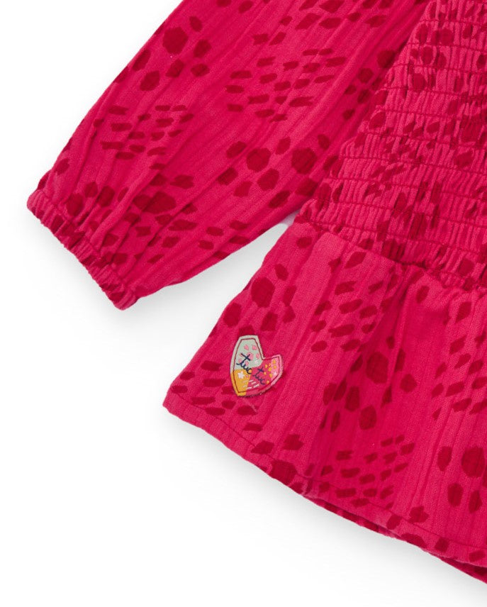 Blusa para niña color fucsia con detalle de nido de abeja.
