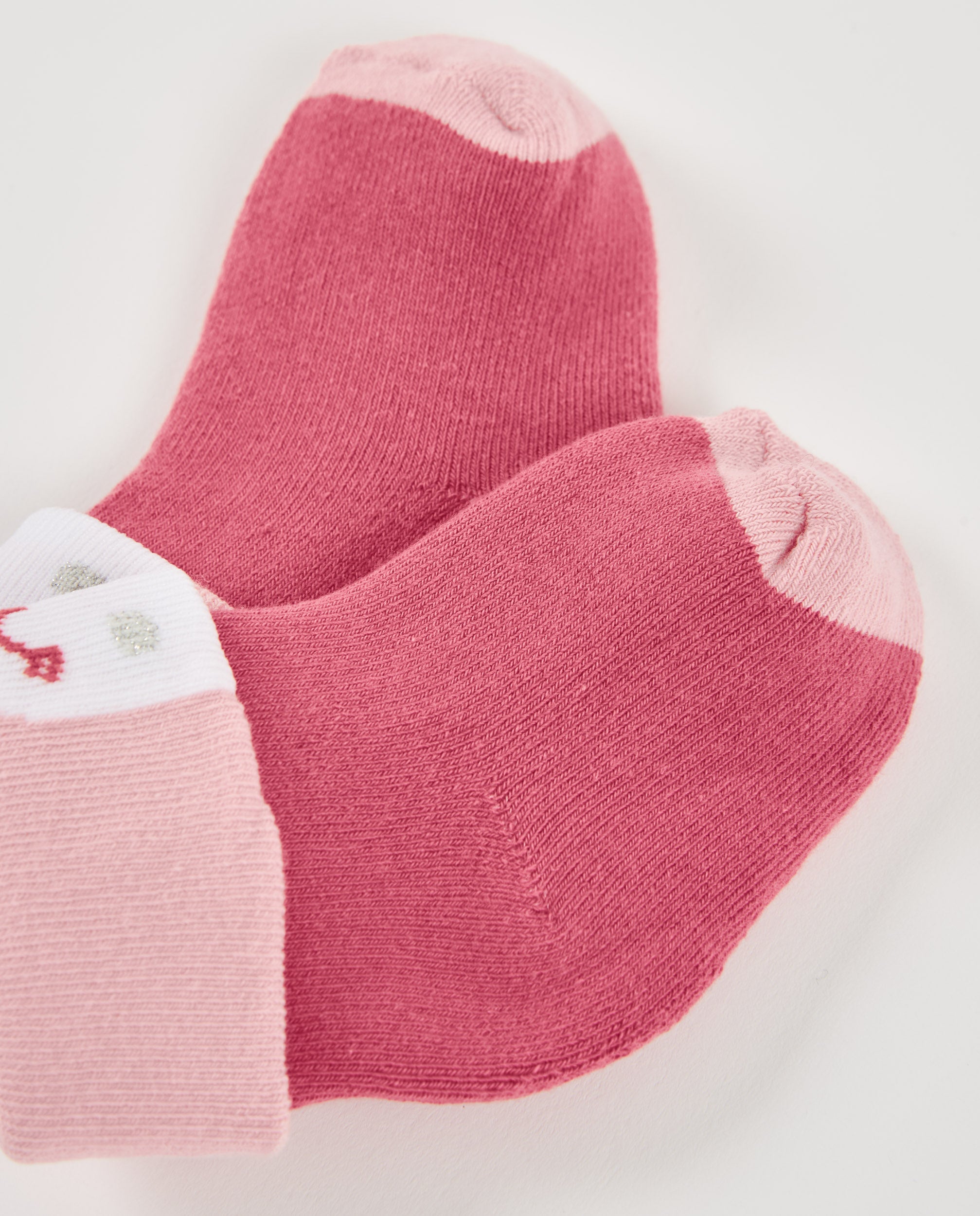 Calcetines de recién nacido en tonos rosa con diseño de carita