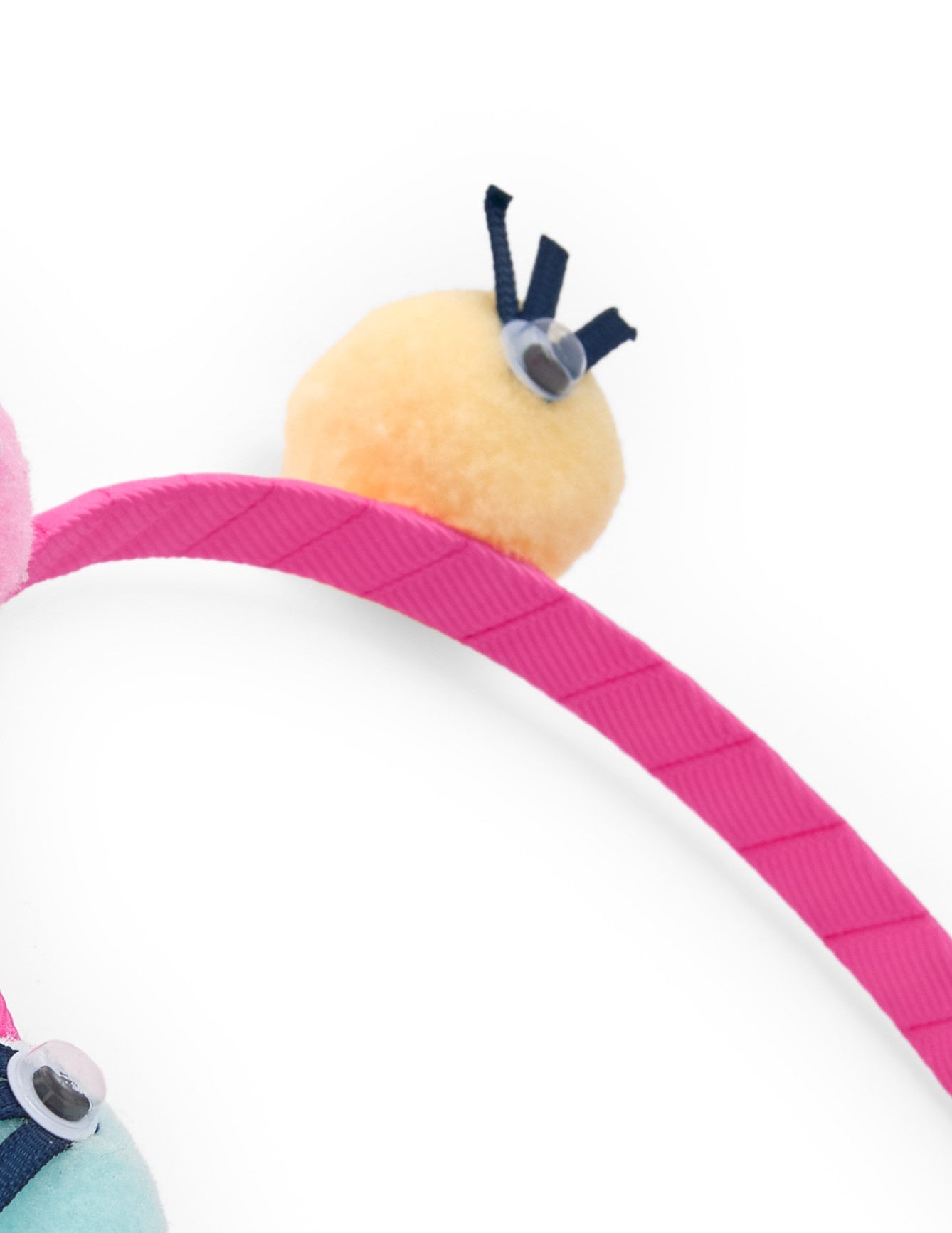 Diadema para niña color rosa con pompones multicolor y ojos