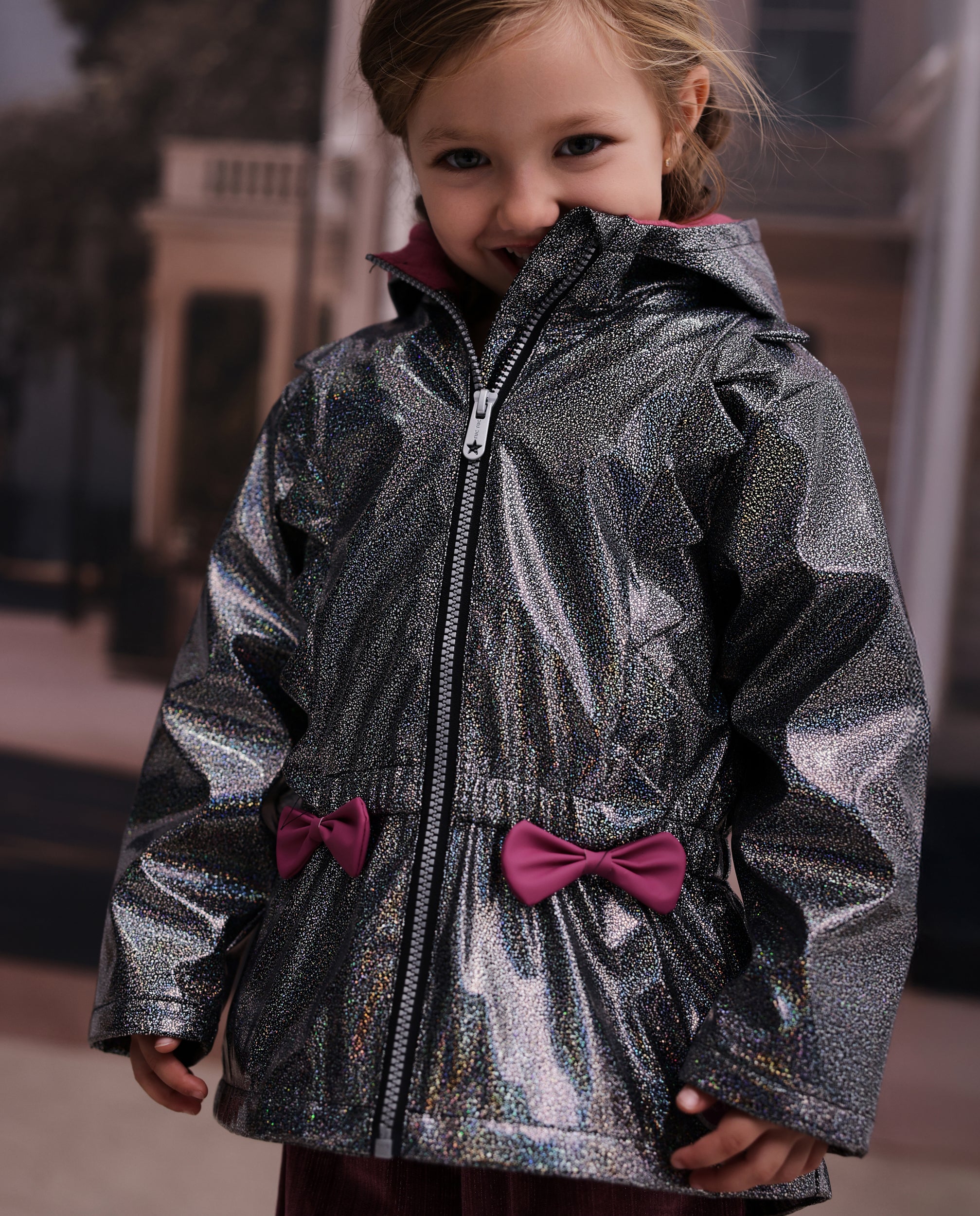 Chubasquero de niña con acabado brillante y lazo decorativo