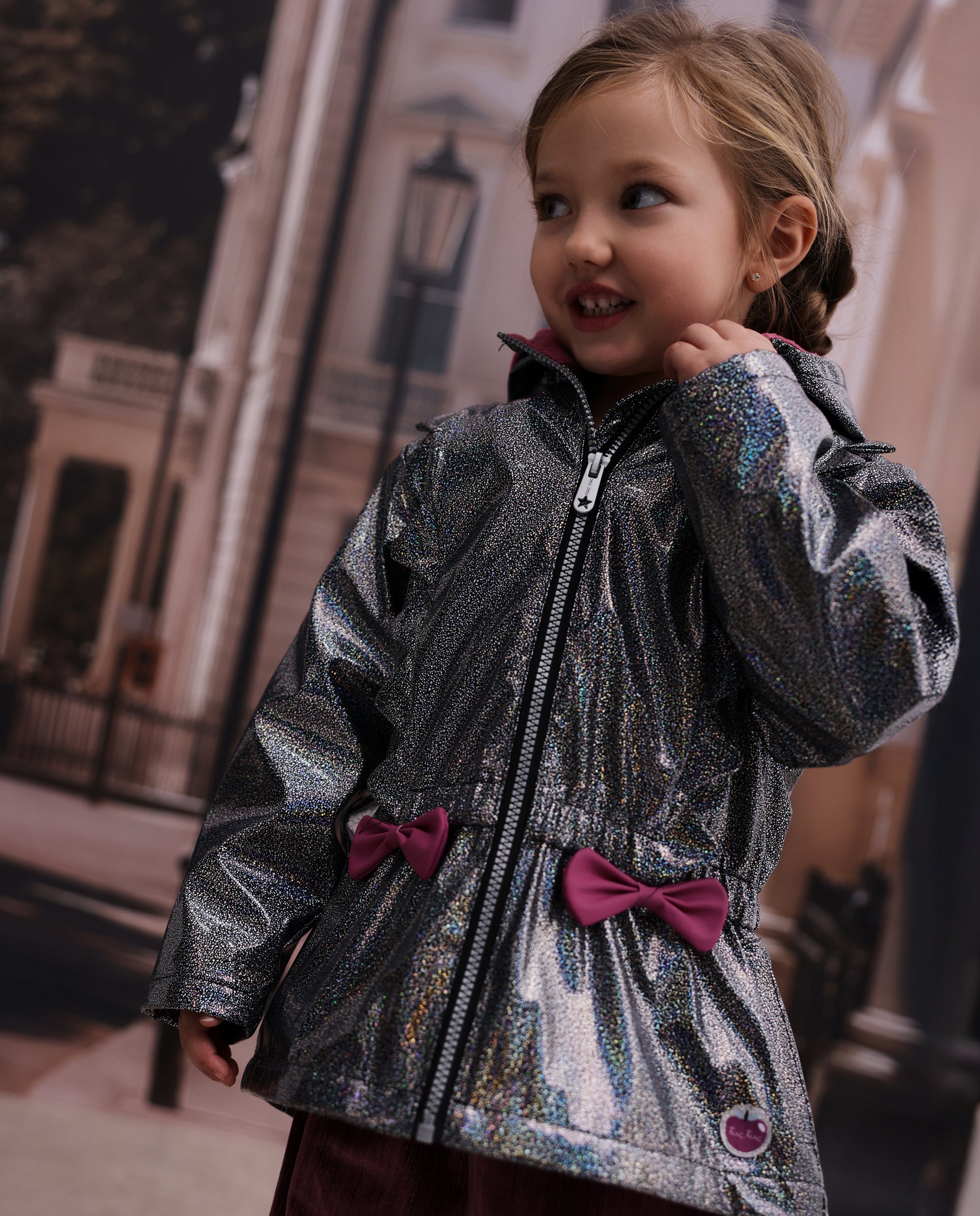 Chubasquero de niña con acabado brillante y lazo decorativo