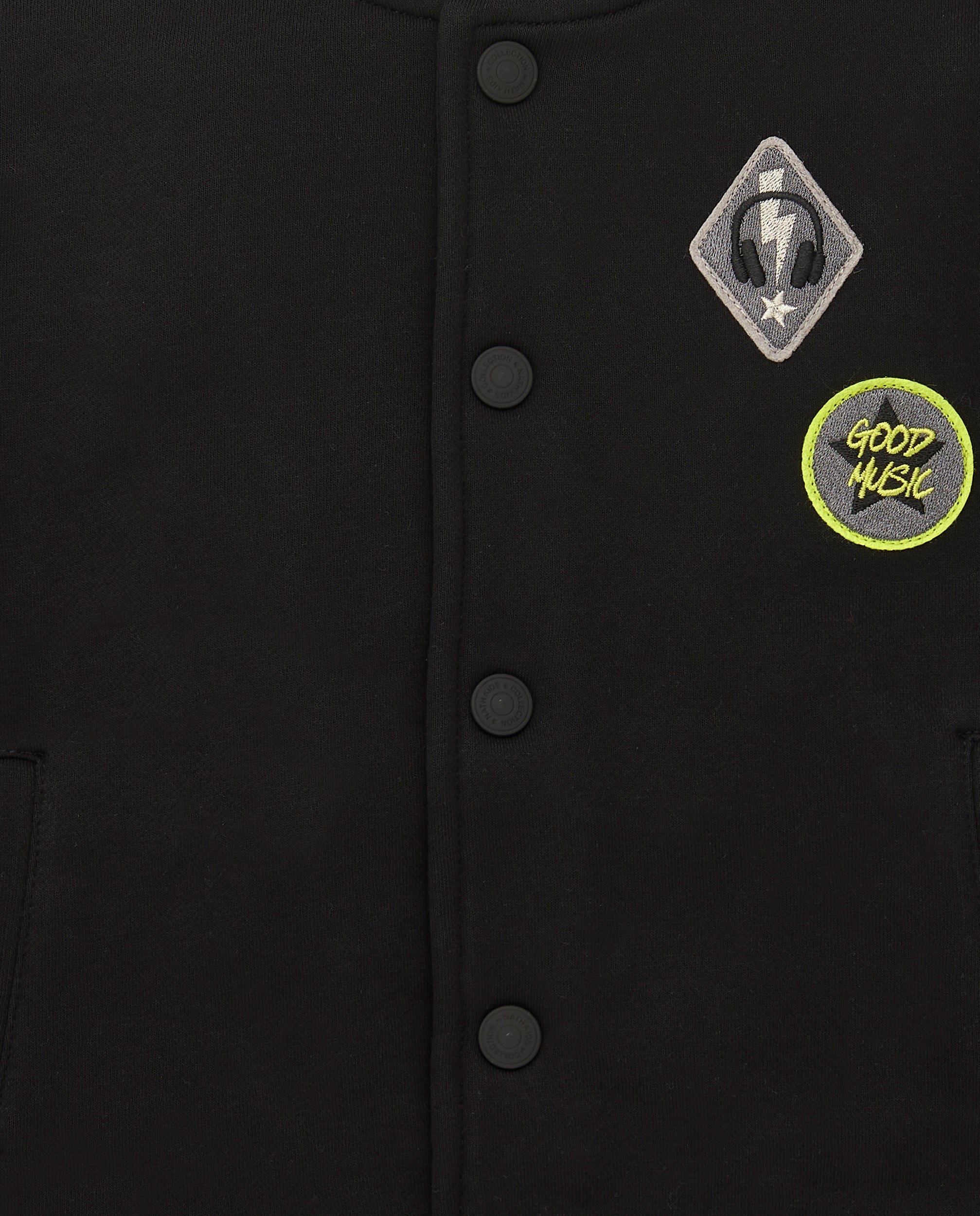Chaqueta estilo varsity negra con detalles verdes para niño de