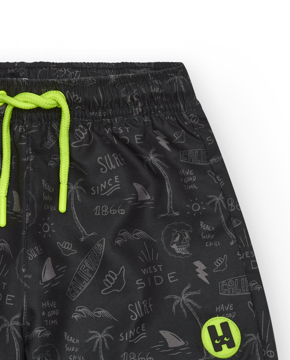 Bañador para niño en negro con estampado surfero y cordón flúor.
