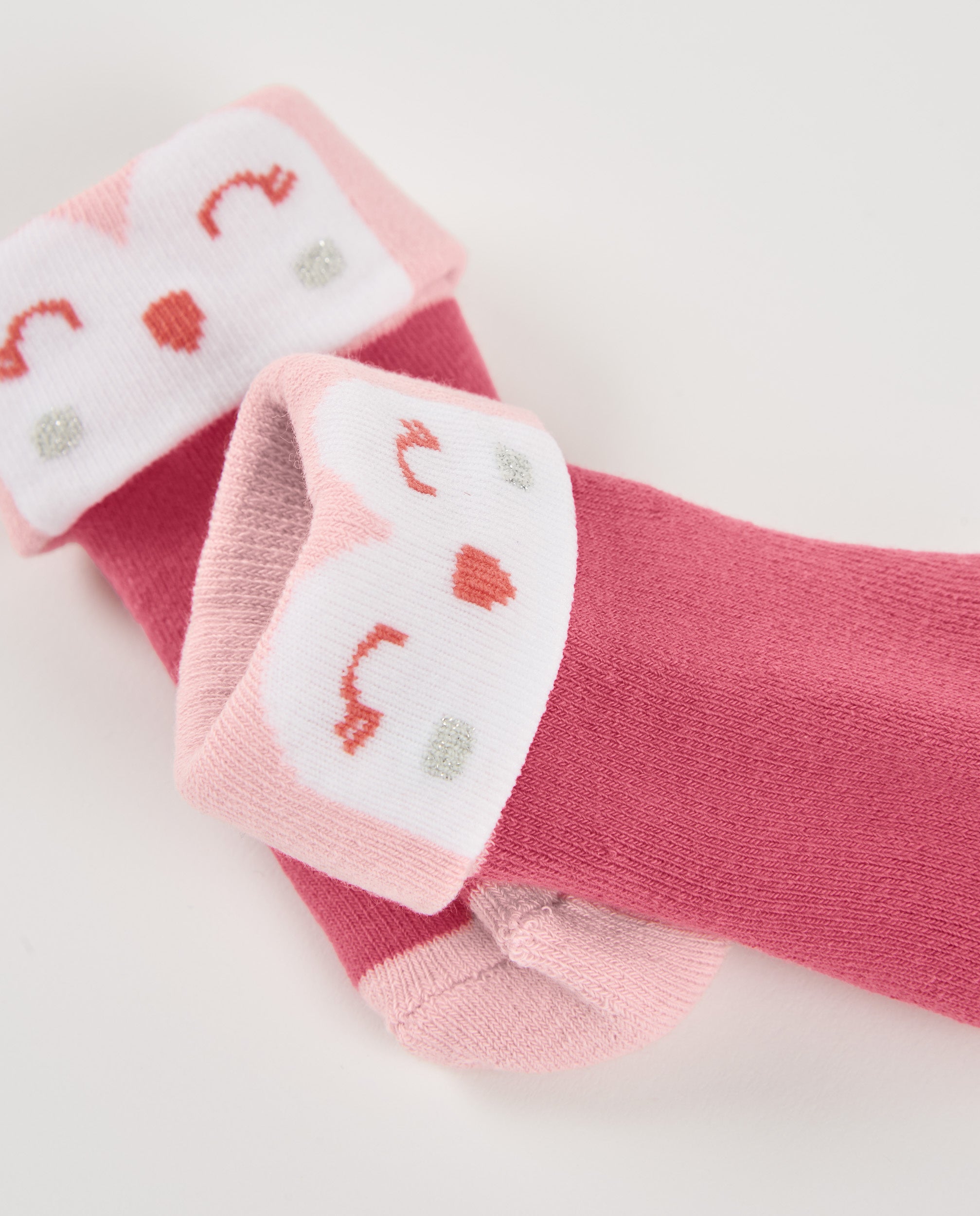Calcetines de recién nacido en tonos rosa con diseño de carita