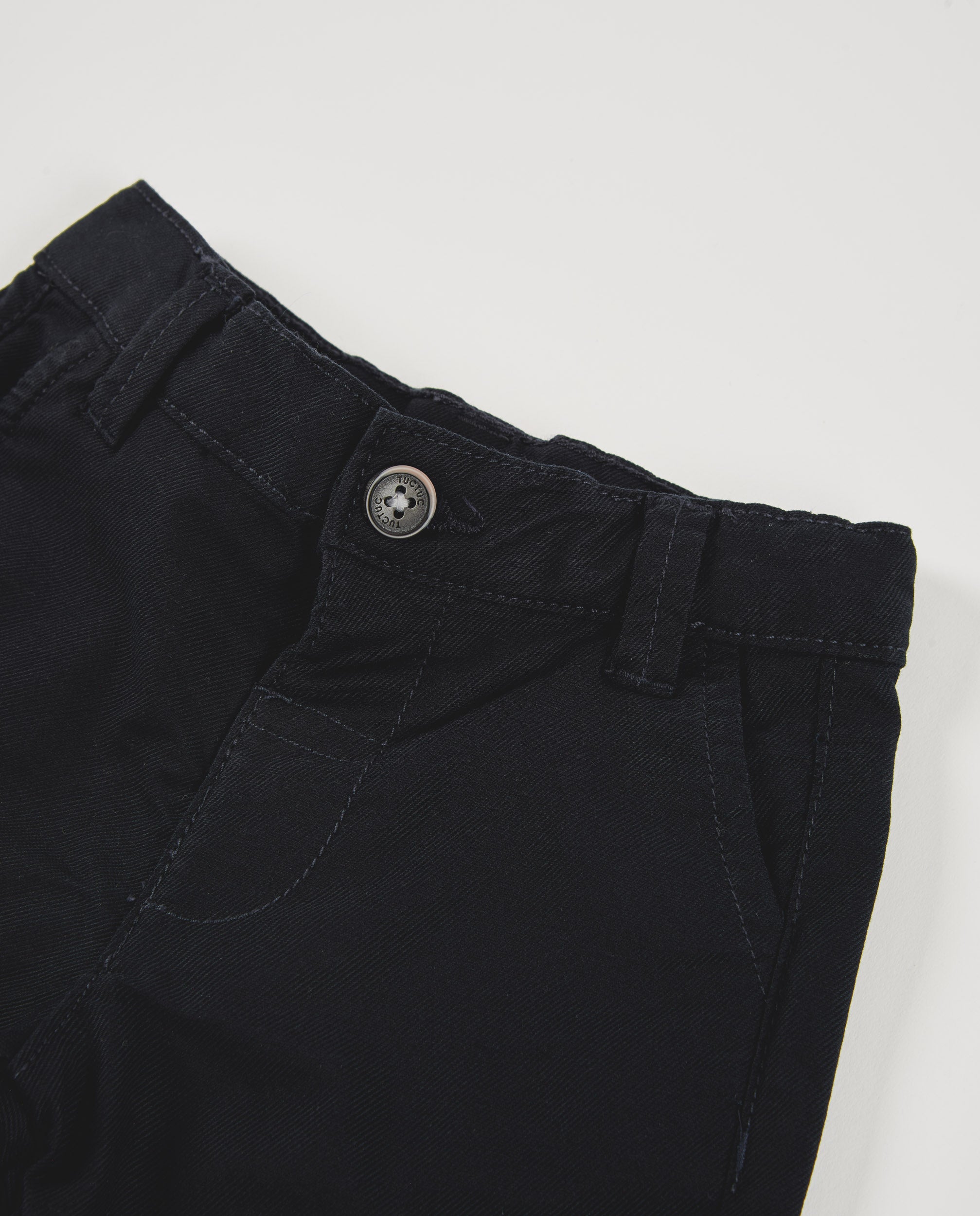Pantalón de niño color negro con bolsillos y vuelta en el bajo