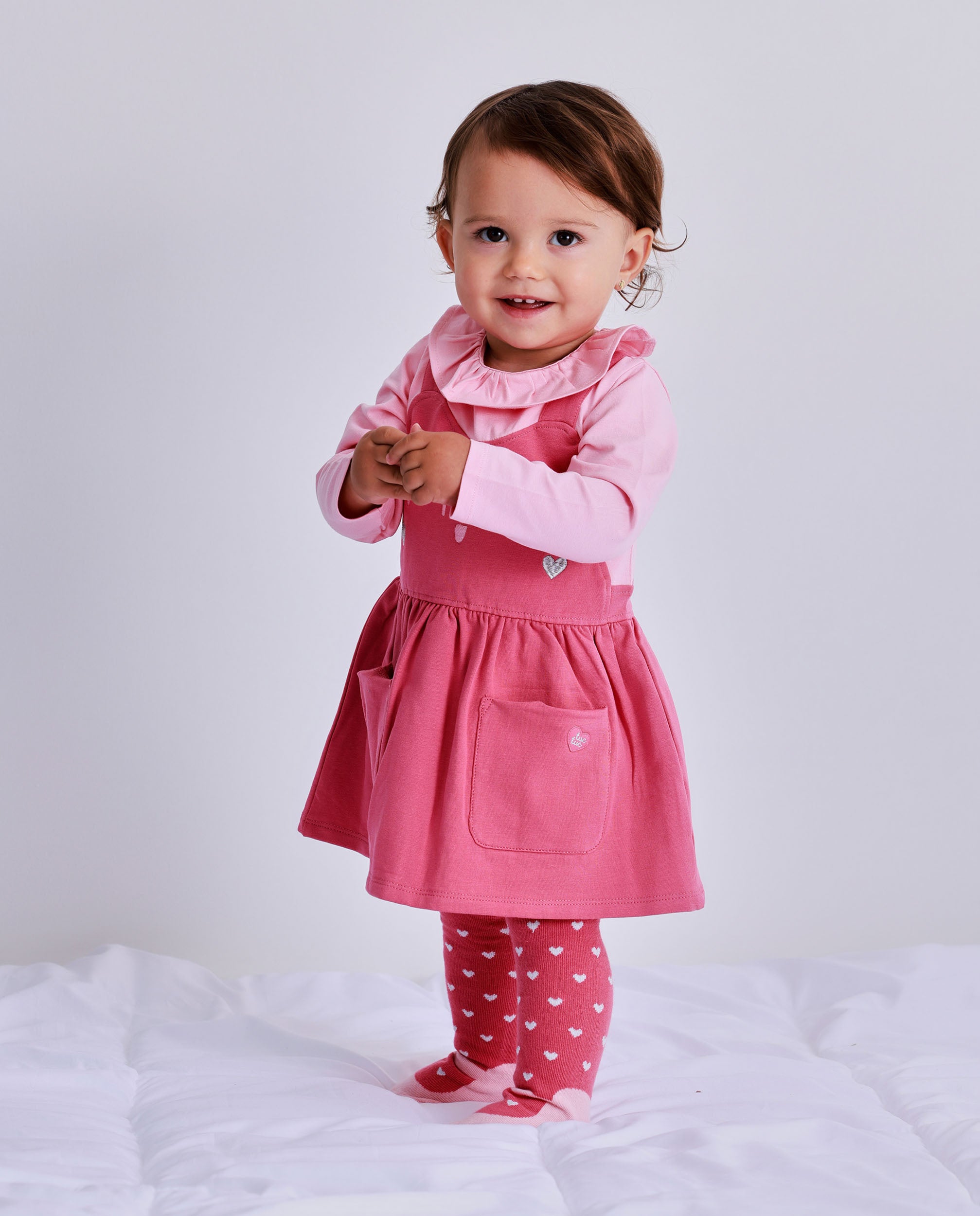 Vestido para recién nacido en tonos rosa con estampado de carita