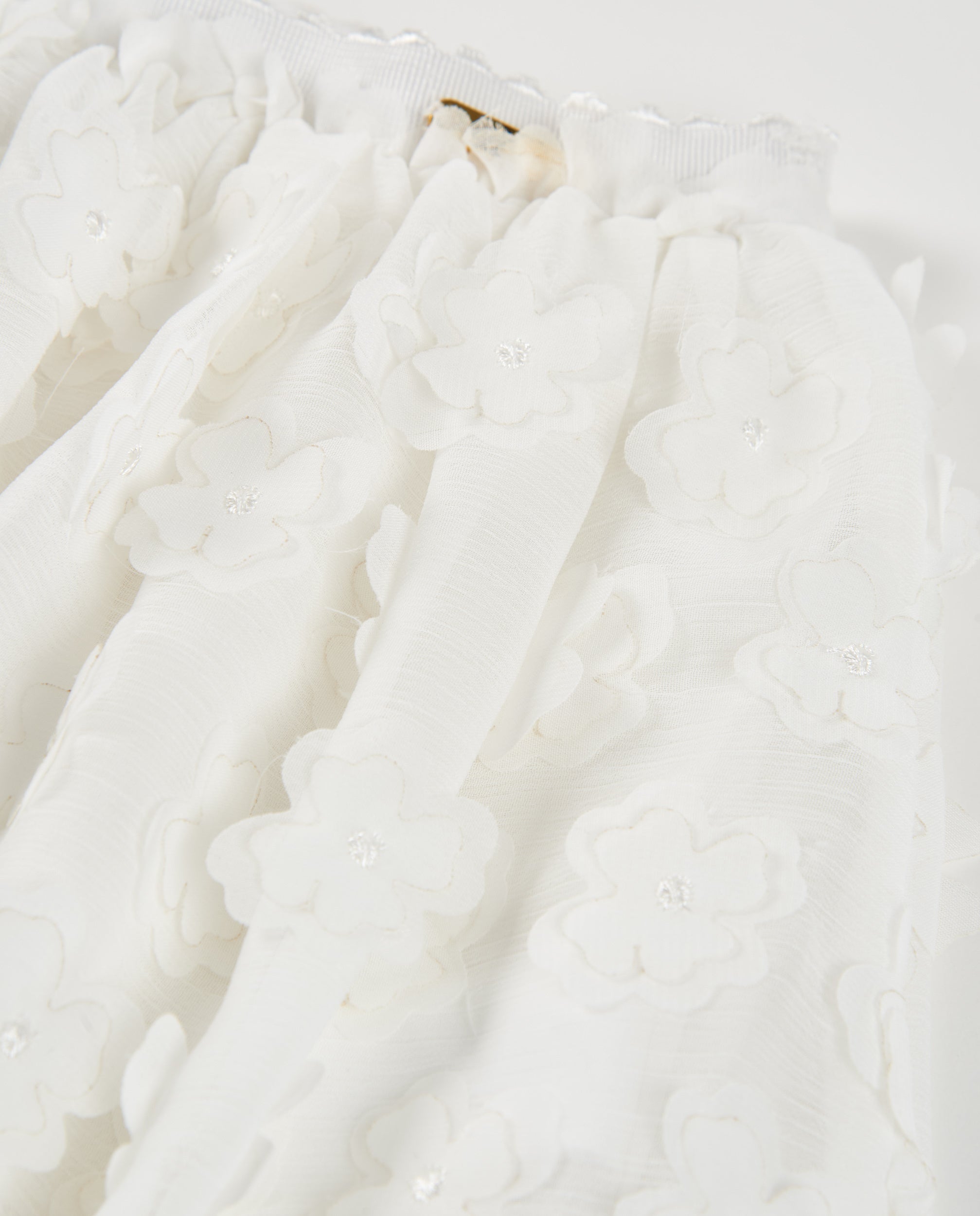Falda de niña de plana con flores en relieve