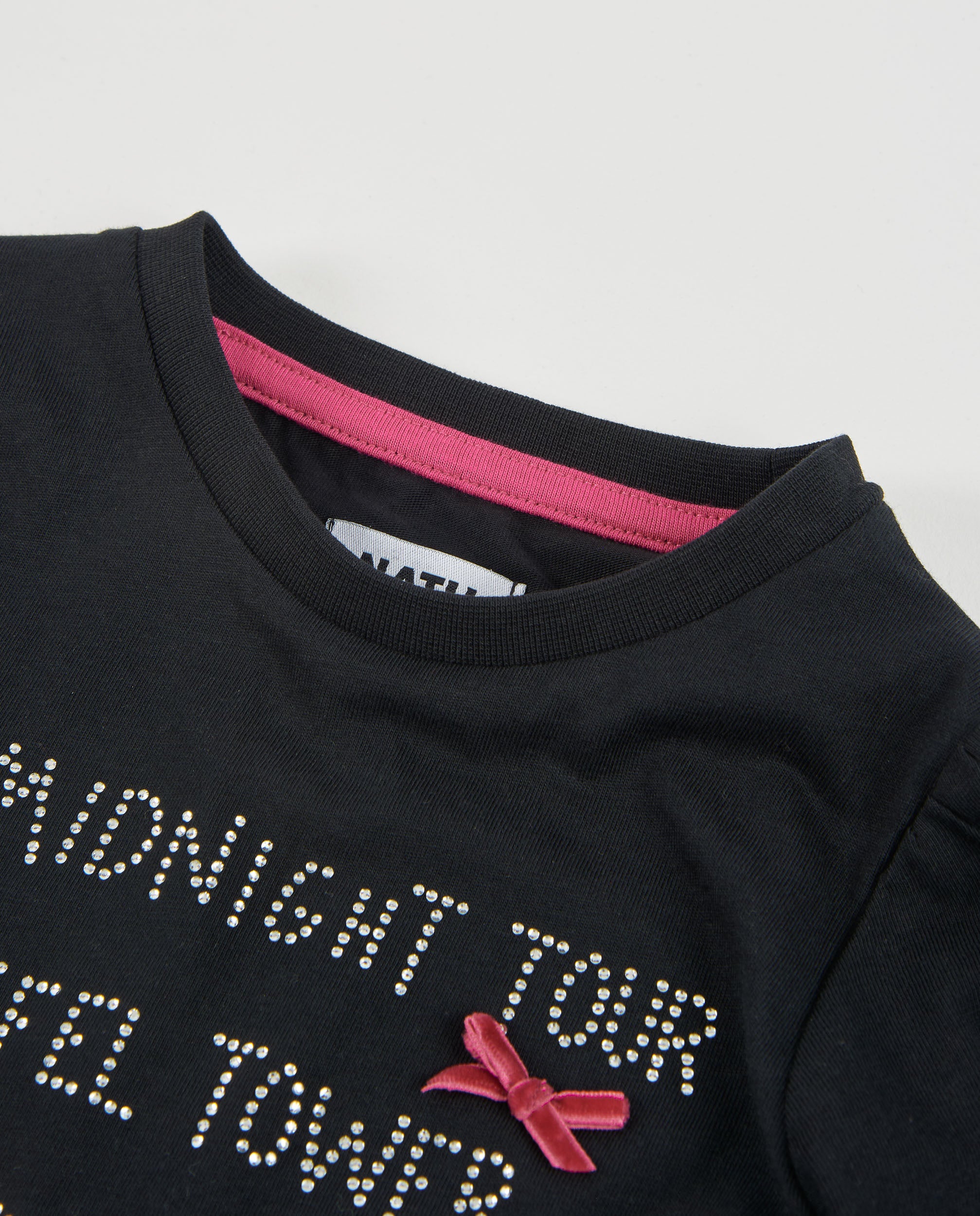 Camiseta de niña de punto con letras brillantes y lazos en fucsia