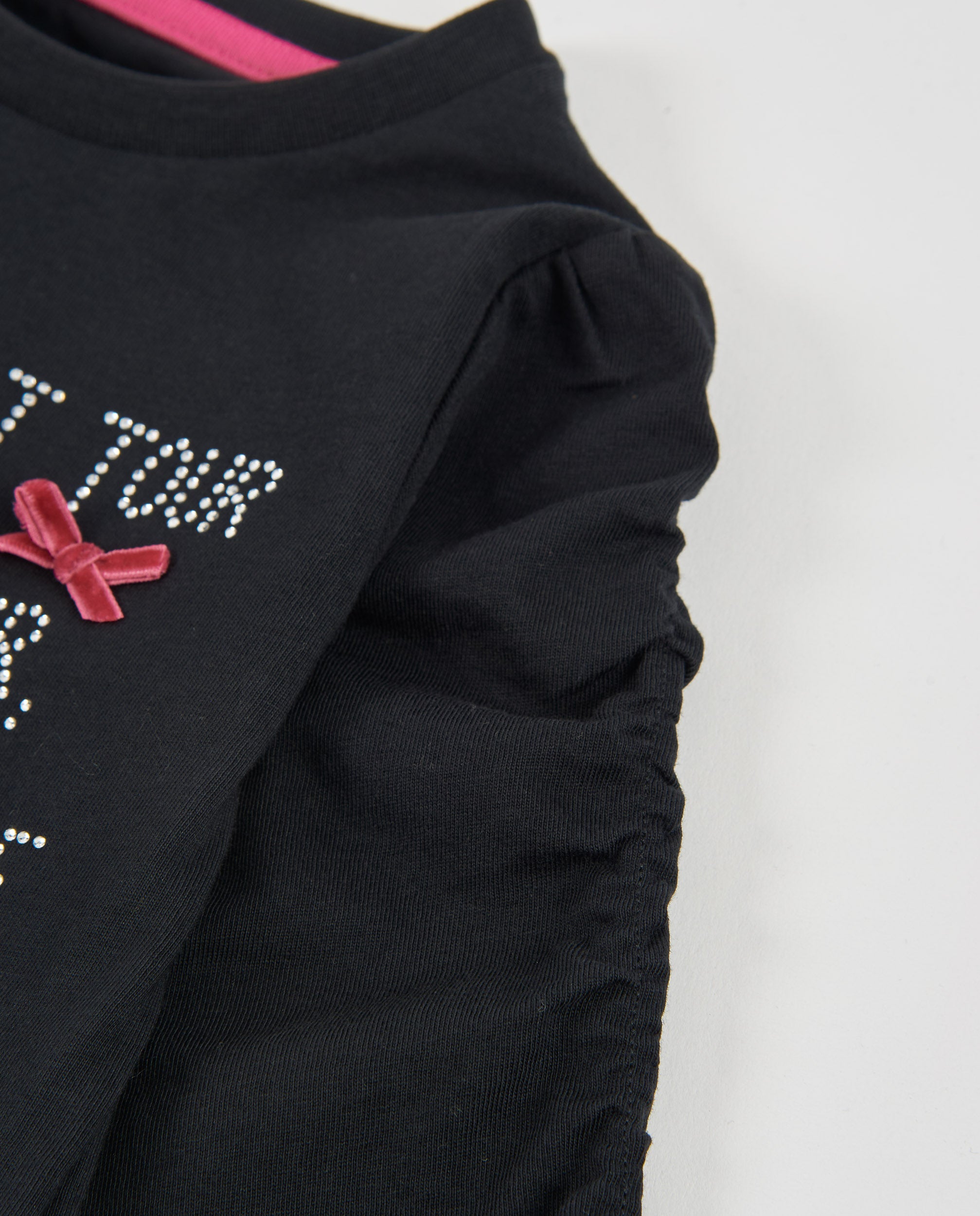 Camiseta de niña de punto con letras brillantes y lazos en fucsia