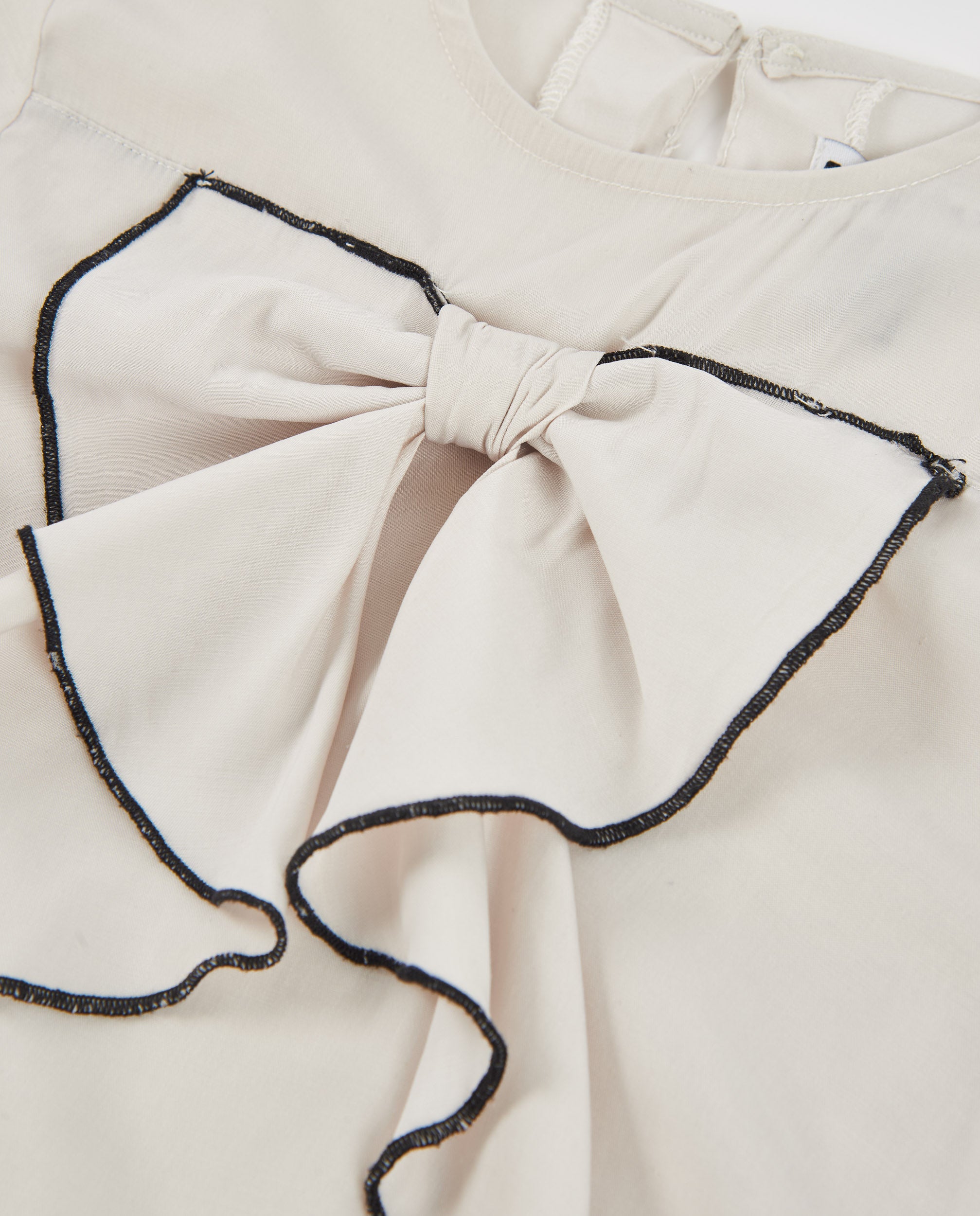 Camisa de niña de tela plana con cuello de volante y lazo central