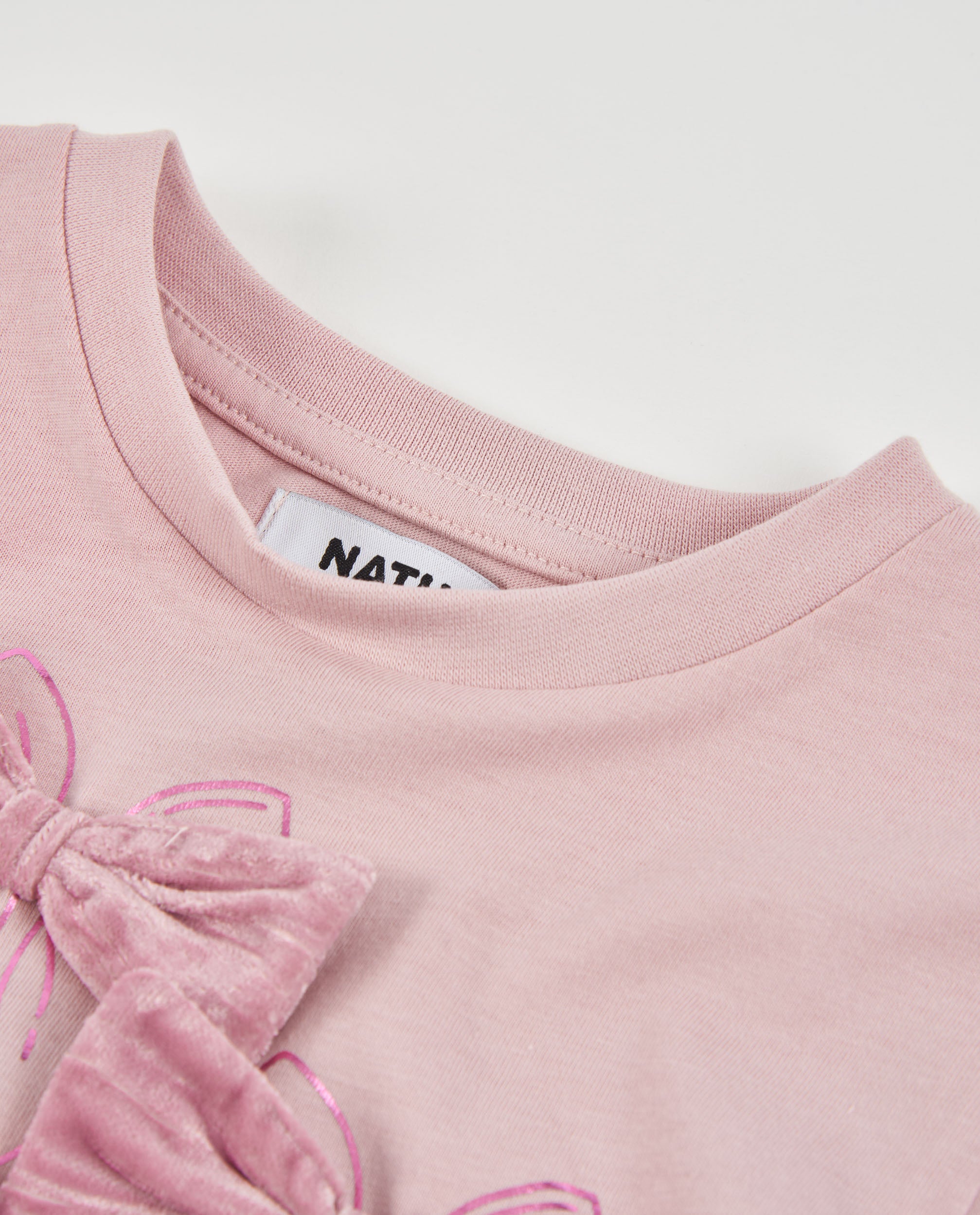 Camiseta de niña de punto con lazos en el pecho y manga larga