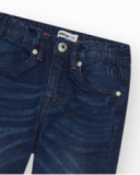 Pantalón vaquero para niño en azul oscuro con efecto desgastado.