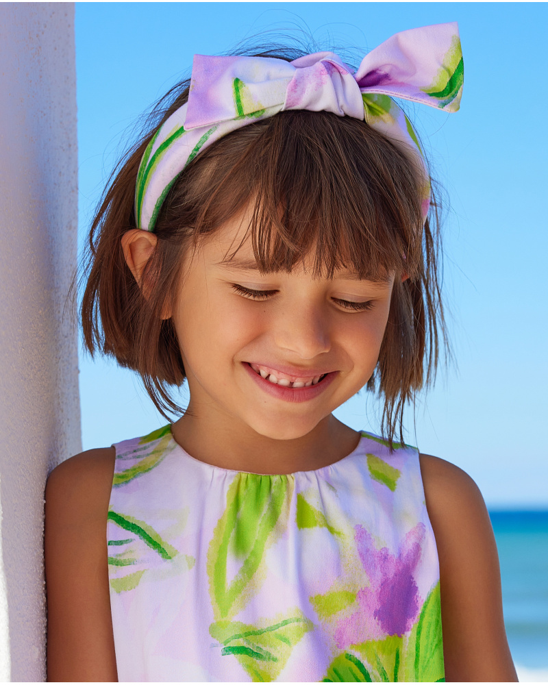 Diadema para niña en tonos lilas con lazo decorativo.