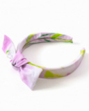 Diadema para niña en tonos lilas con lazo decorativo.