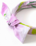 Diadema para niña en tonos lilas con lazo decorativo.