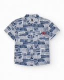 Chemise blanche pour garçon avec imprimé géométrique bleu et poche décorative.