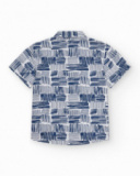 Chemise blanche pour garçon avec imprimé géométrique bleu et poche décorative.