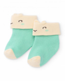Chaussettes pour nouveau-né en vert et crème avec motif visage souriant.