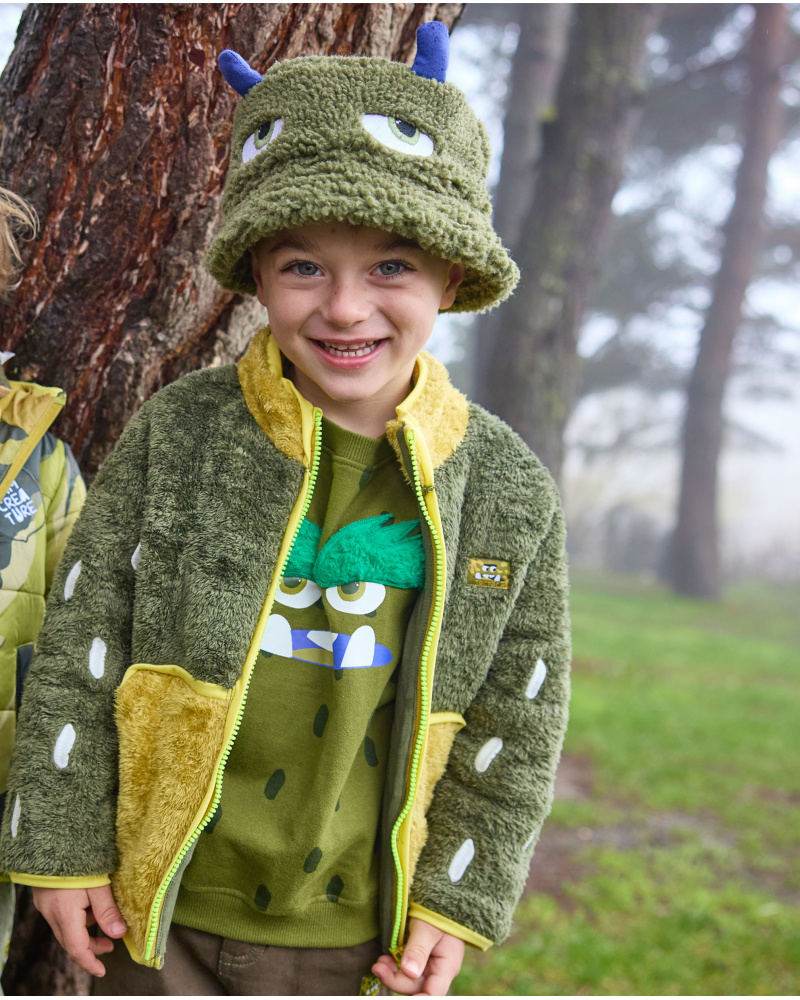 Veste en peluche pour fille en tons vert et jaune avec fermeture éclair frontale.