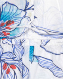 Tuta corta per bambina in bianco con vita elastica e stampa floreale.