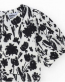 Abito per bambina in bianco e nero con maniche a sbuffo e stampa floreale.