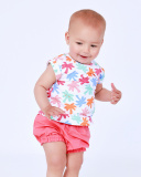 Completo bianco e corallo per bambina con t-shirt di foglie tropicali e pantaloncini arricciati |