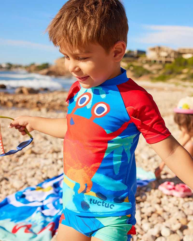 T-shirt da bagno per bambino blu con maniche rosse e design di granchio