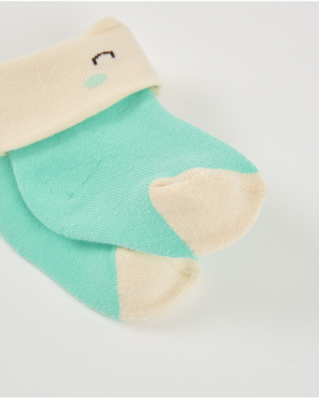 Calzini per neonato in verde e crema con design di faccina sorridente.