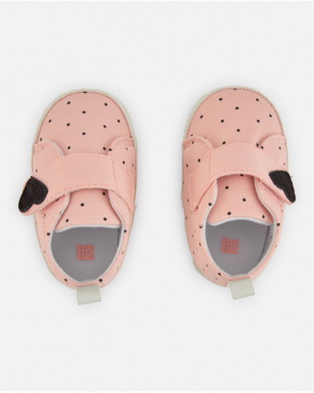 Scarpa per neonato colore rosa con stampa a pois neri e chiusura in velcro.