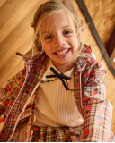 Maglia a costine per bambina in écru con volant e fiocco